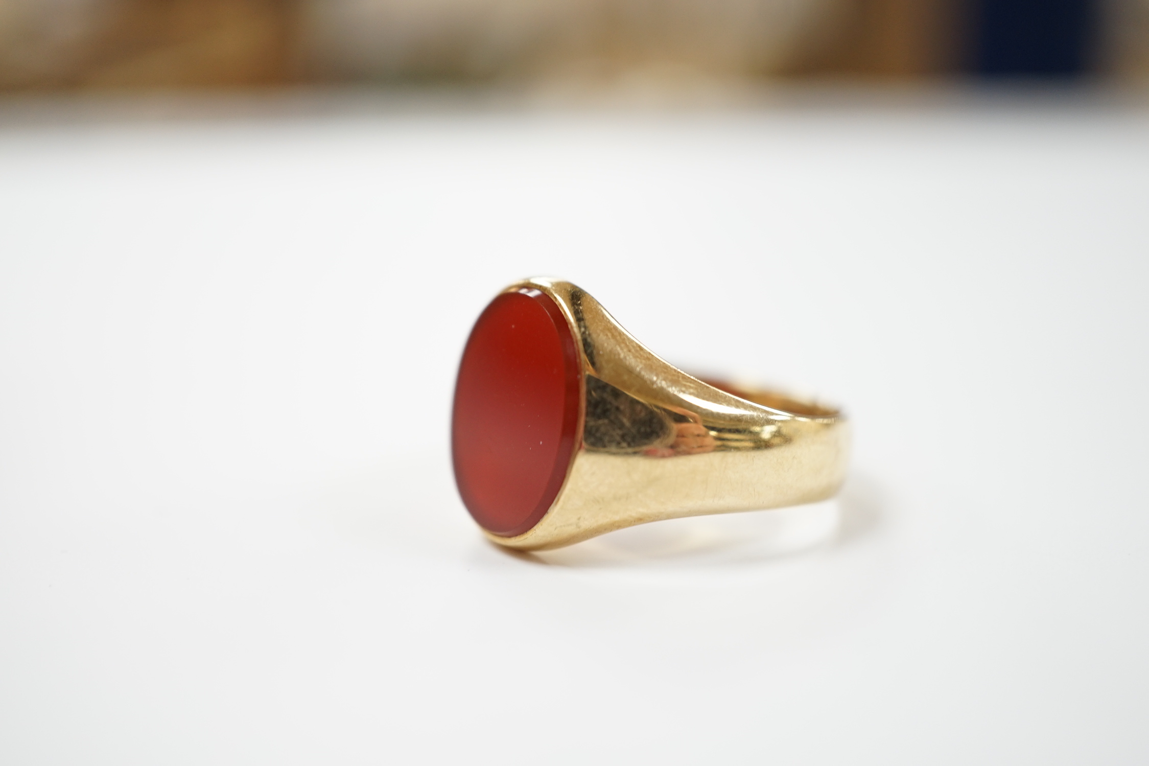 A 9ct gold and single stone oval carnelian set signet ring, size W, gross weight 8.7 grams.